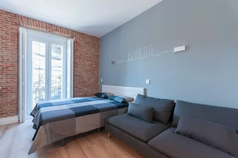 bed and sofa brick faced apartment in Madrid Spain