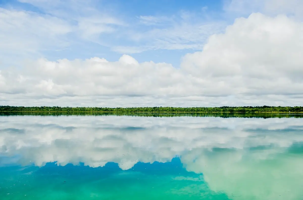 Clear turquoise lake reflecting clouds