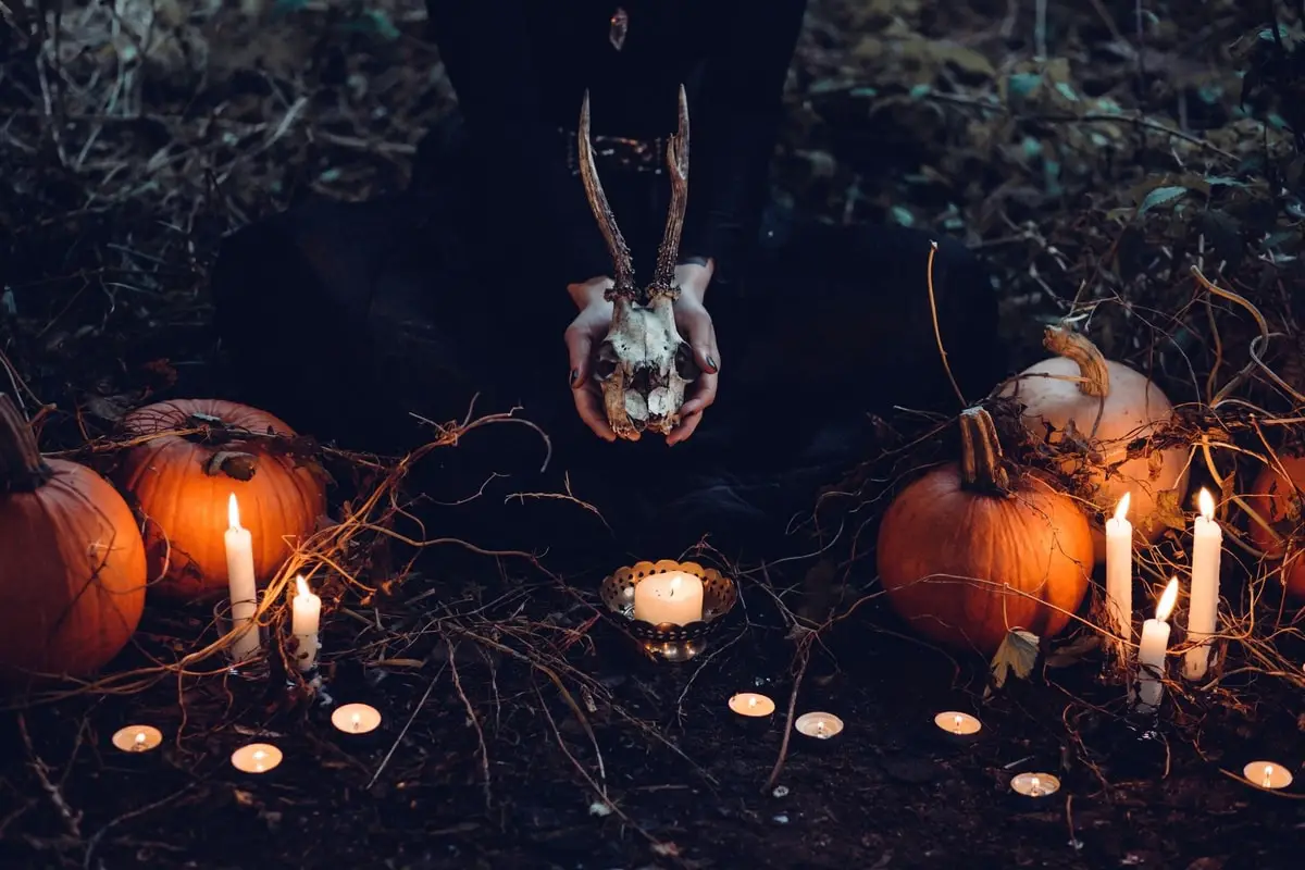 Halloween witchcraft ritual setup with candles and pumpkins