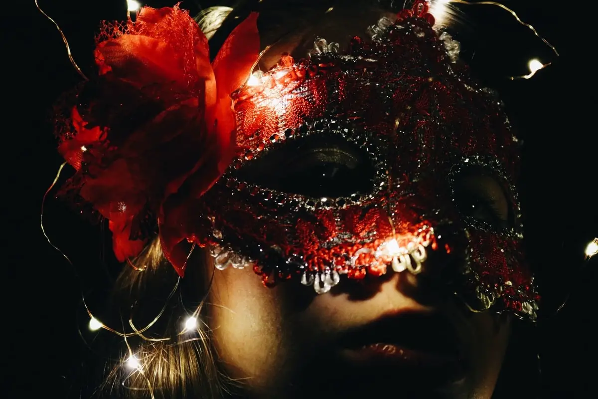 Closeup of woman's face in a red masquerade mask
