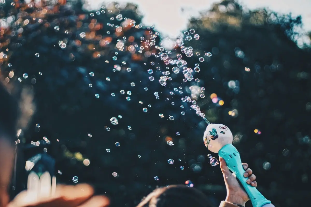 A child playing with bubbles in a park